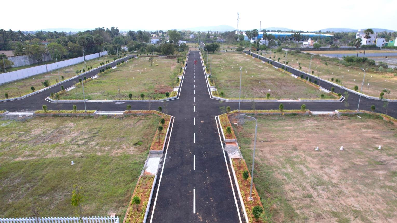 Aerial view of a gated plot layout with wide roads and landscaping, developed by real estate companies in Hyderabad